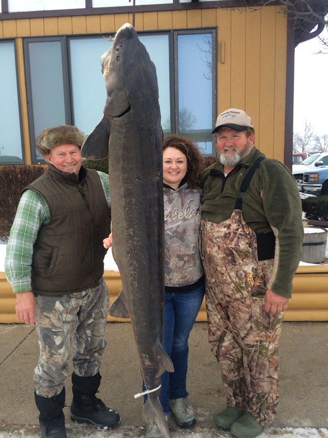 For the Muche family and many others, the Lake Winnebago sturgeon season is all about family, fun and big fish. Rachael Mathwig celebrates her success with her grandfather, on the left, and her father on the right.   - Photo credit: Ryan Koenigs